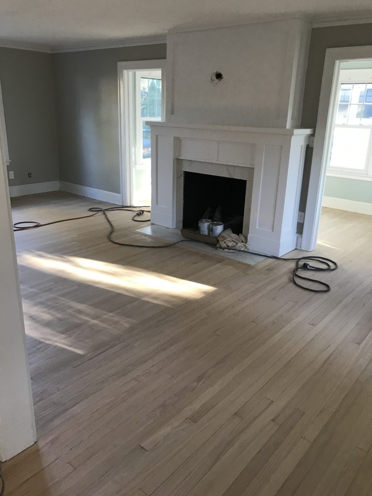 fireplace makeover before and after photos - white paint added to the wood panels over the brick