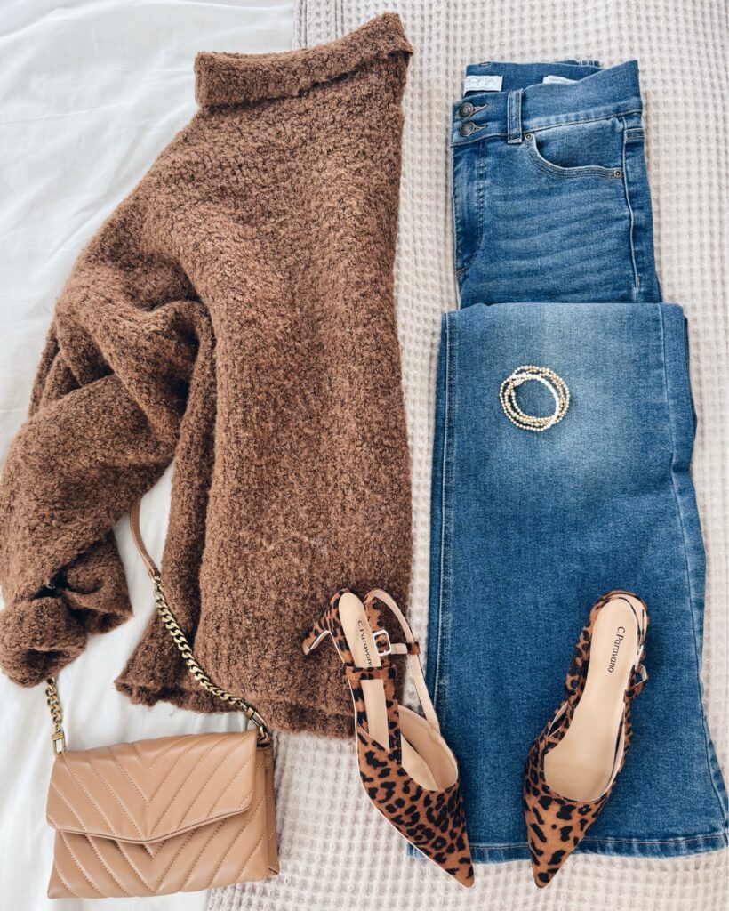 Trendy fall outfit for women over 40 featuring a cozy brown turtleneck sweater, dark-wash denim, nude quilted handbag, and statement leopard print slingback heels.